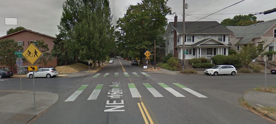 The NE Tillamook greenway crossing NE 15th Avenue, featuring green "crossbike" markings on the asphalt to let drivers know bikers will be crossing the road.