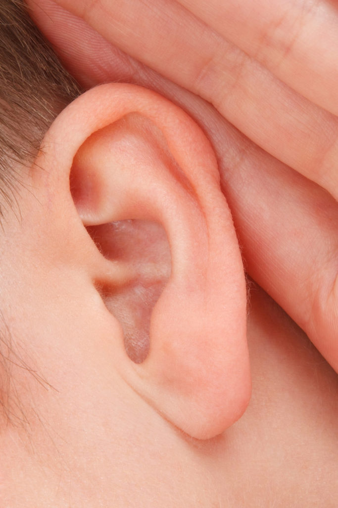 male with hand behind listening ear