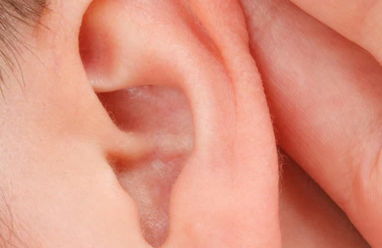 male with hand behind listening ear